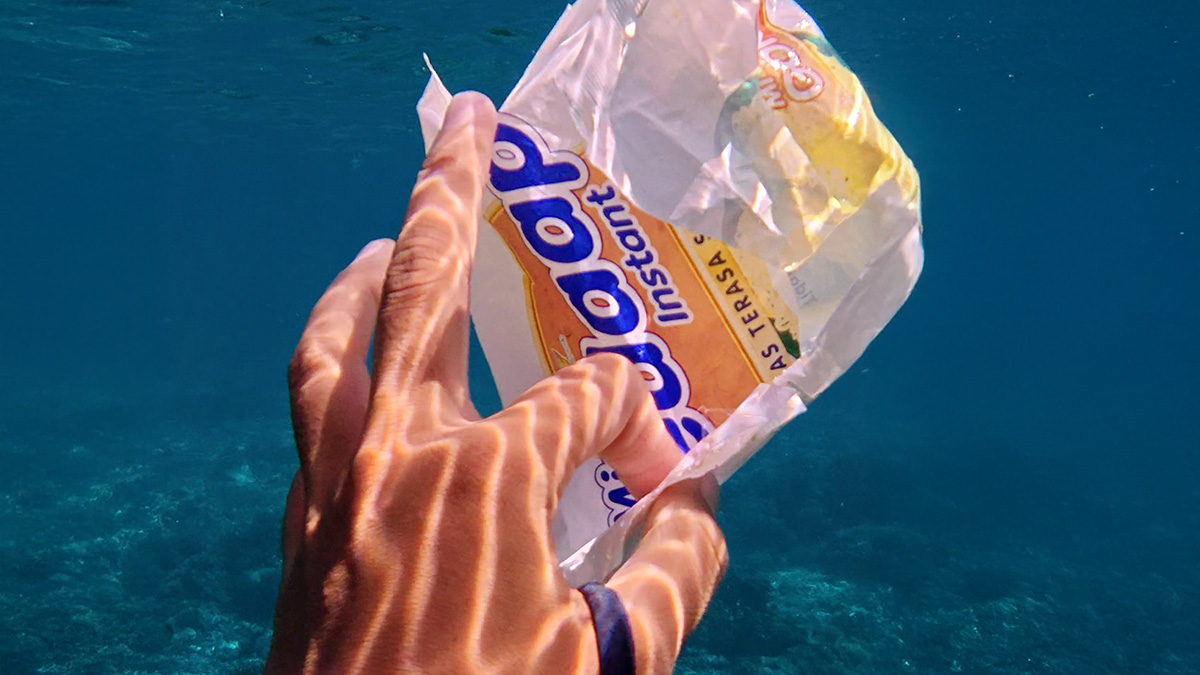 Tourist swimming past instant noodle package in Indonesia.