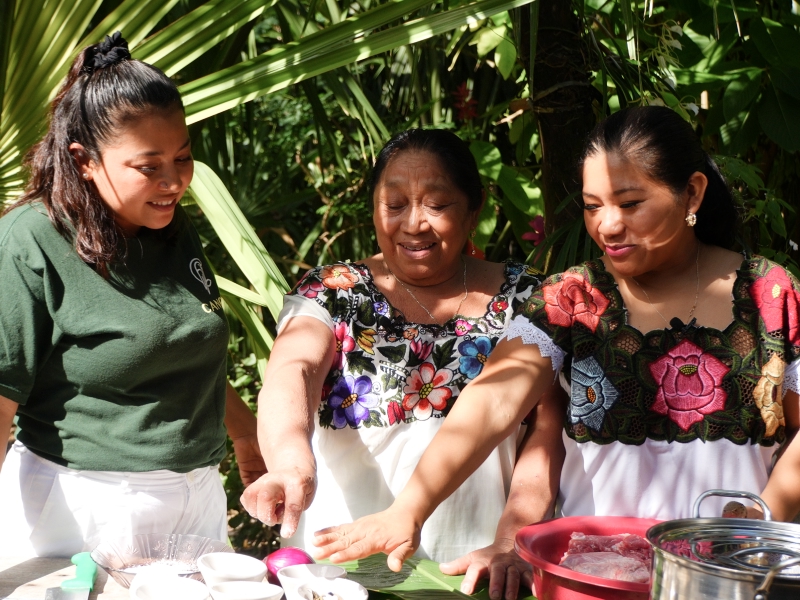 Mayan women showing tourist how to cook Mexican recipes